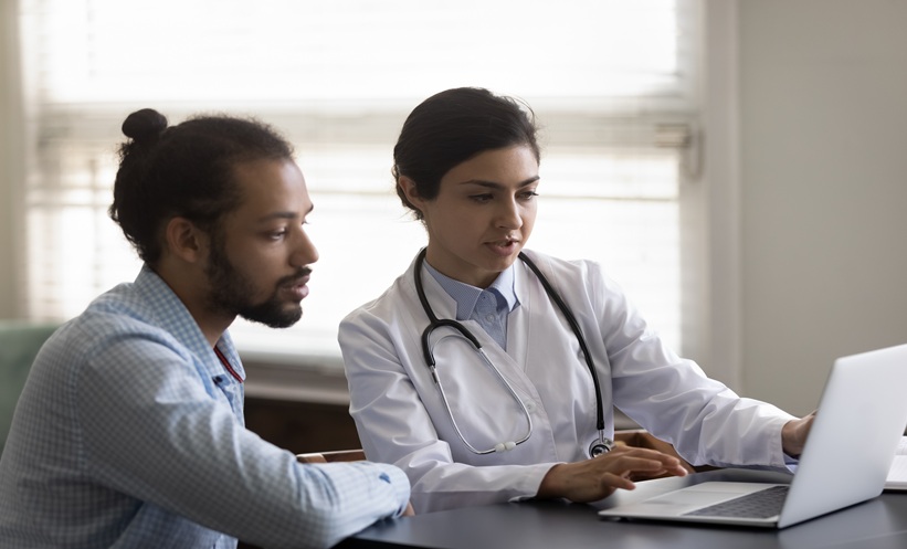 Dermatologist reviewing cutaneous squamous cell carcinoma imaging for staging and surveillance