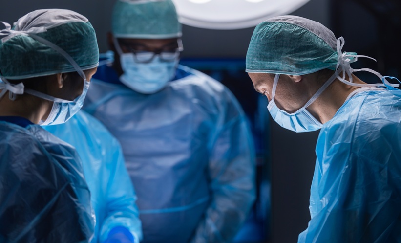 Surgical team performing a quadruple organ transplant involving retransplanted lungs, a liver, and a kidney.