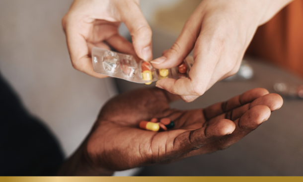 Pills being placed in a person's hand
