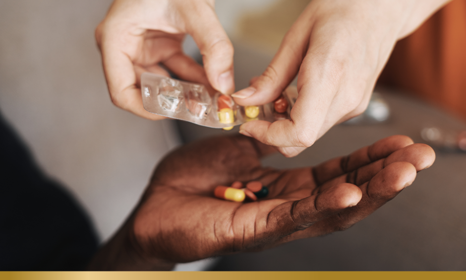 Pills being placed in a person's hand