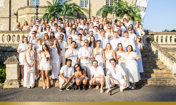 Group picture of EMJ employees dressed in all white standing on steps