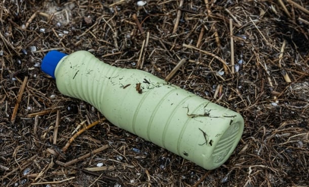 Plastic pollution from bottle on dirt