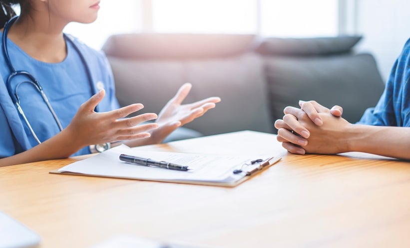 Physician discussing sexual dysfunction in chronic hepatitis B during a confidential patient consultation.