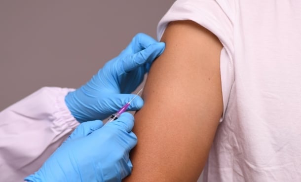 Clinician preparing an MMR vaccine amid rising Pennsylvania measles cases and two confirmed deaths.