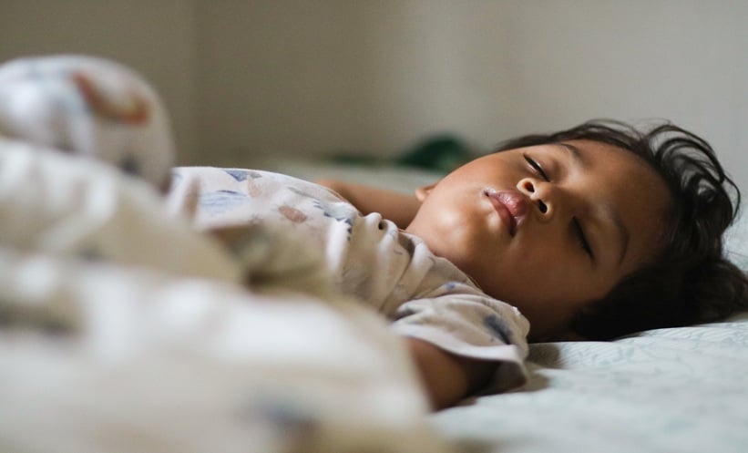Child sleeping at home, illustrating secondhand smoke and sleep fragmentation in children.