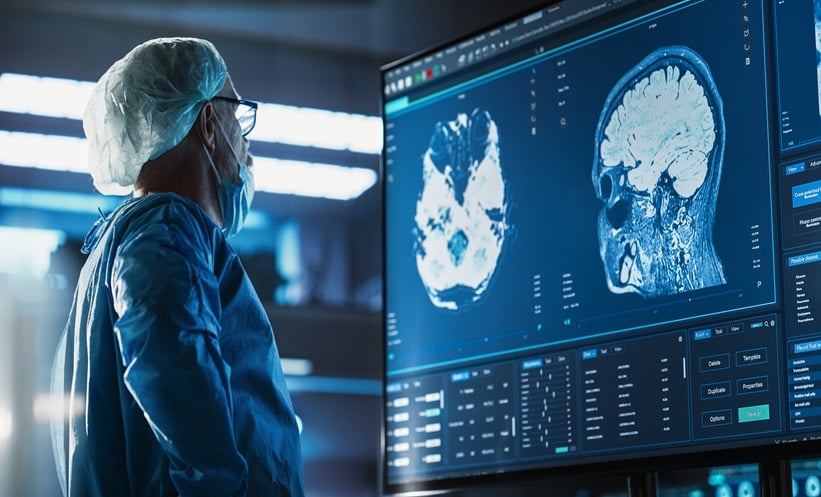 Brain surgeon looking at a scan of a person brain before they do surgery