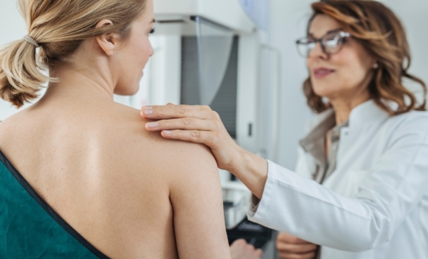 Female doctors checks the breast of another woman for signs of cancer