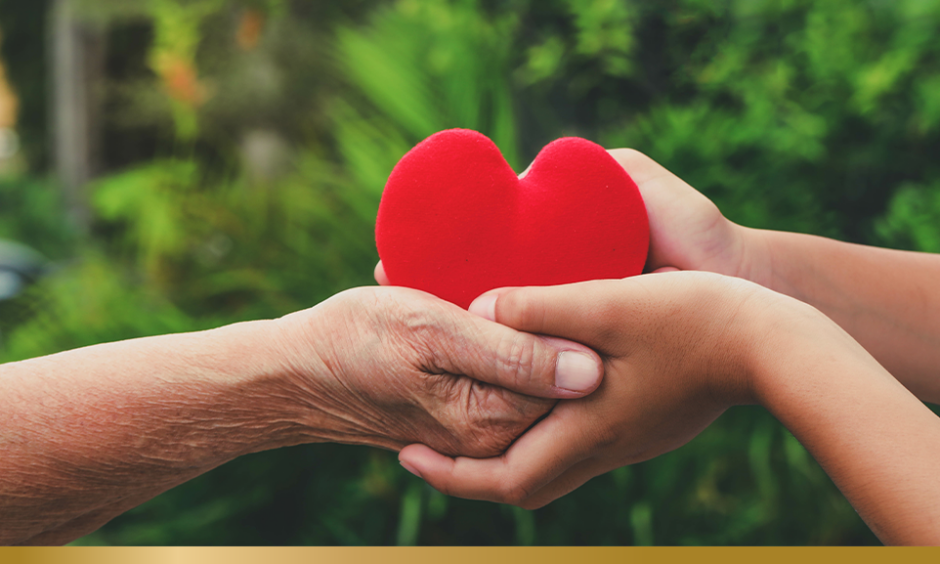 Two people holding a red heart