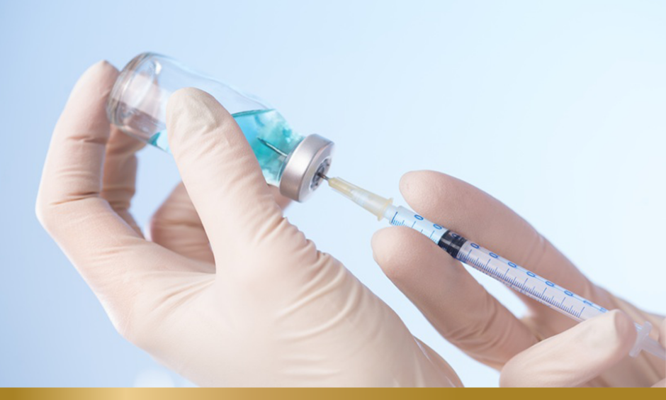 Person in white gloves drawing from a vaccine vial