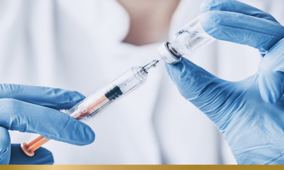 Healthcare professional wearing blue latex gloves prepares vaccine