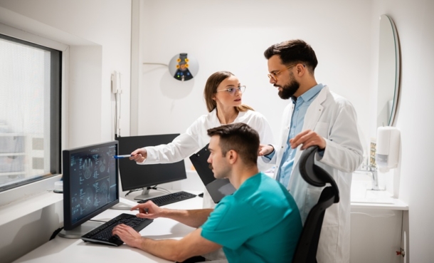 Medical imaging specialists reviewing diagnostic scans on a computer.