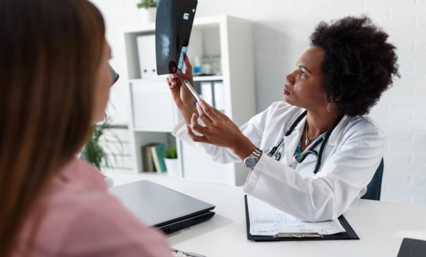 Doctor reviews an X-ray with a patient during a consultation.