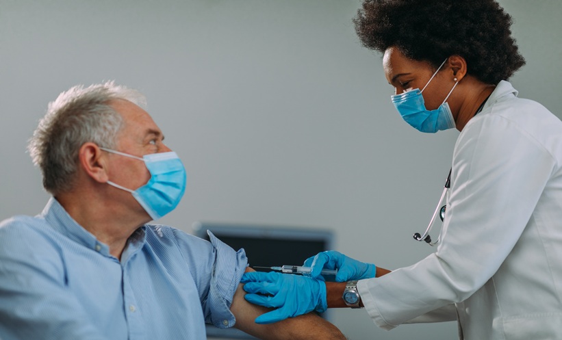 Physician discussing shingles vaccine uptake with an older adult during a preventive care visit.