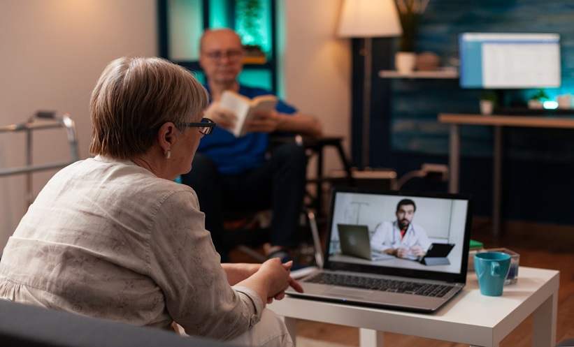 Older woman speaking with a physician by video call from her living room.