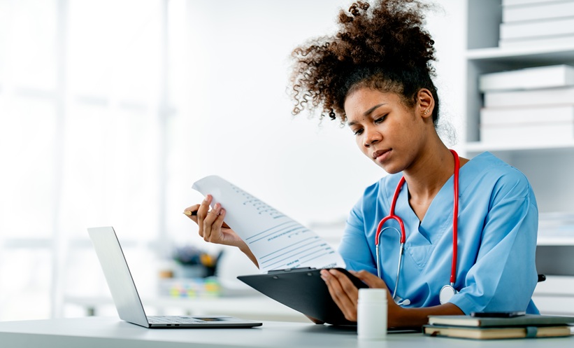 Healthcare professional reviewing a patient’s medications and medical records to assess HIV polypharmacy.