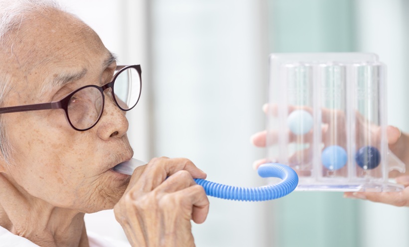 Older adult completing a breathing test to assess lung function.