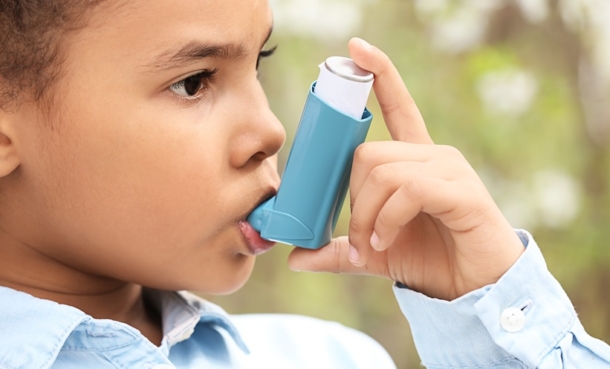 child holding asthma inhaler