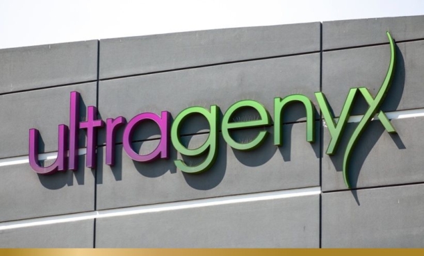 Ultragenyx logo, green an purple, on the side of a building.
