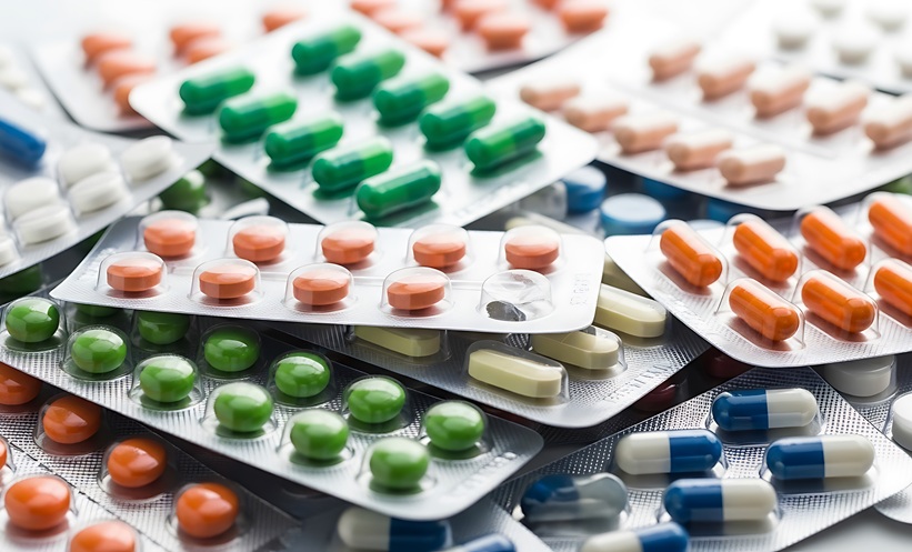 Picture of many foil blister packs of oral medications and pills, all in different shapes sizes and colours