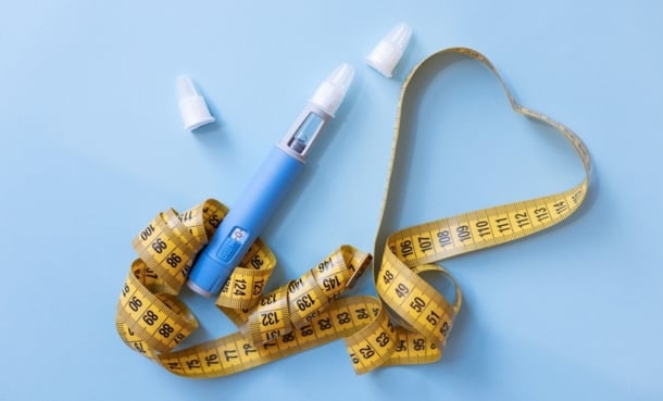 weight loss inection with a yellow tape measure in a posed object picture