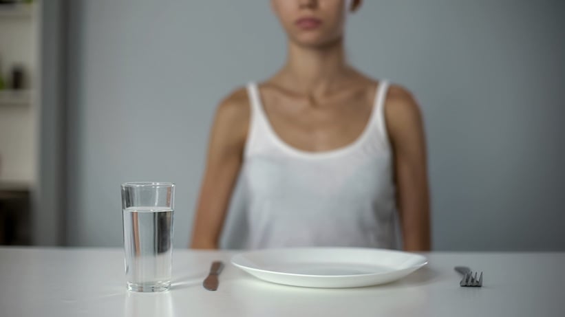 Person with empty plate in front of them