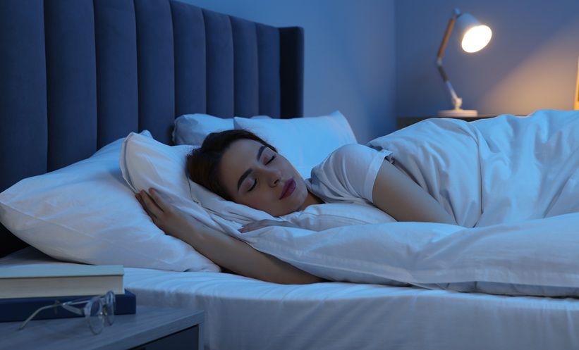 Person sleeping in room with light on