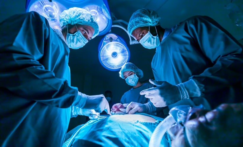 Surgeons carrying out an organ transplant in an operating theatre