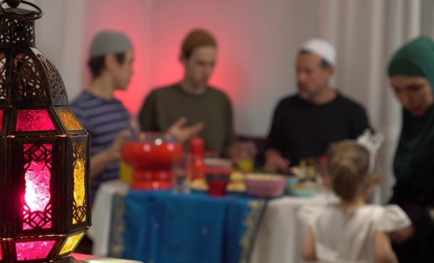 Authentic Muslims family around the table. Iftar is the evening meal with which Muslims end their daily Ramadan fast at sunset. They break their fast at the time of the call to prayer for the evening