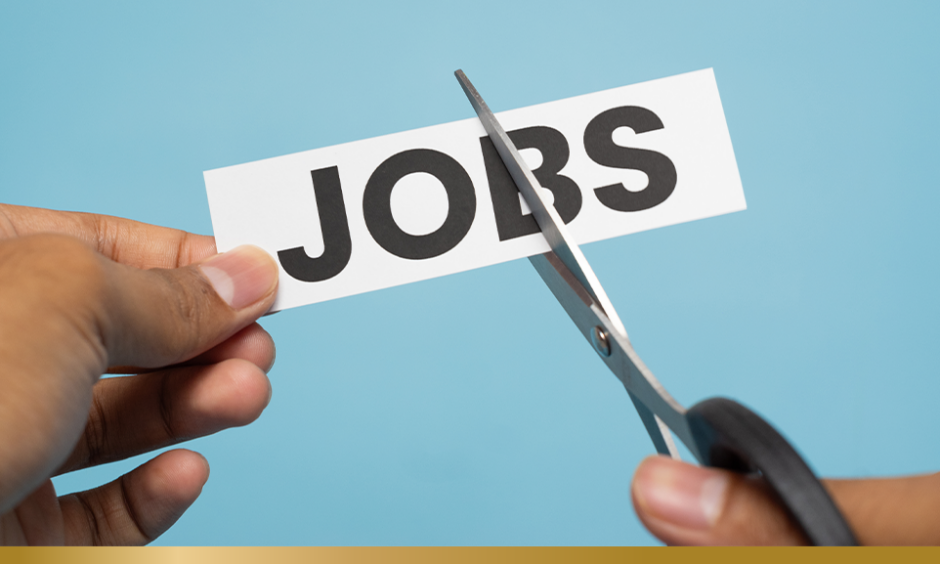Pair of scissors cutting a piece of paper with JOBS written on it