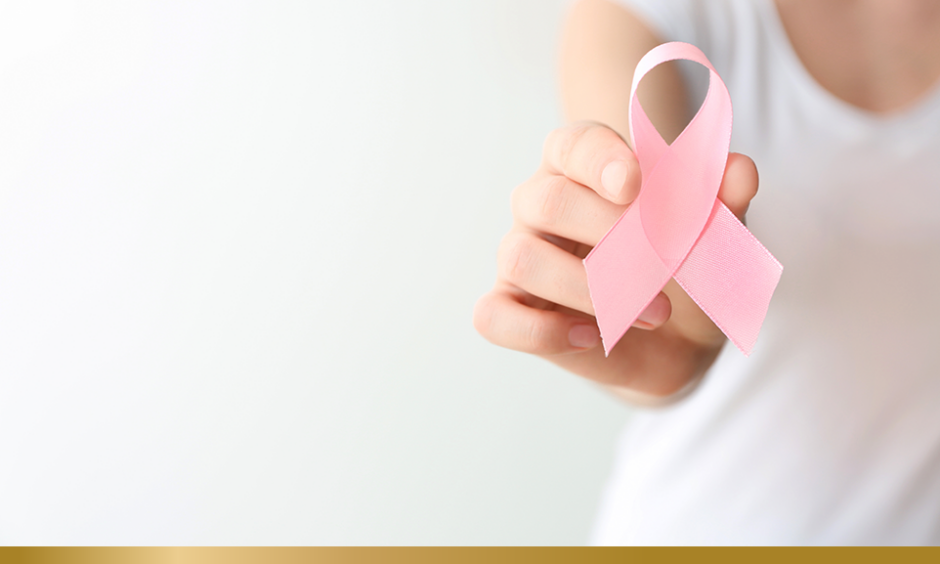 Woman holding pink ribbon on light background, closeup. Breast cancer awareness concept
