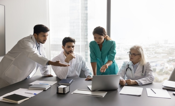Physicians reviewing severe asthma biologic treatment decisions using clinical data and artificial intelligence.