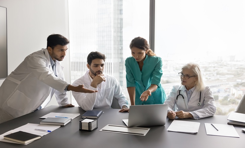 Physicians reviewing severe asthma biologic treatment decisions using clinical data and artificial intelligence.