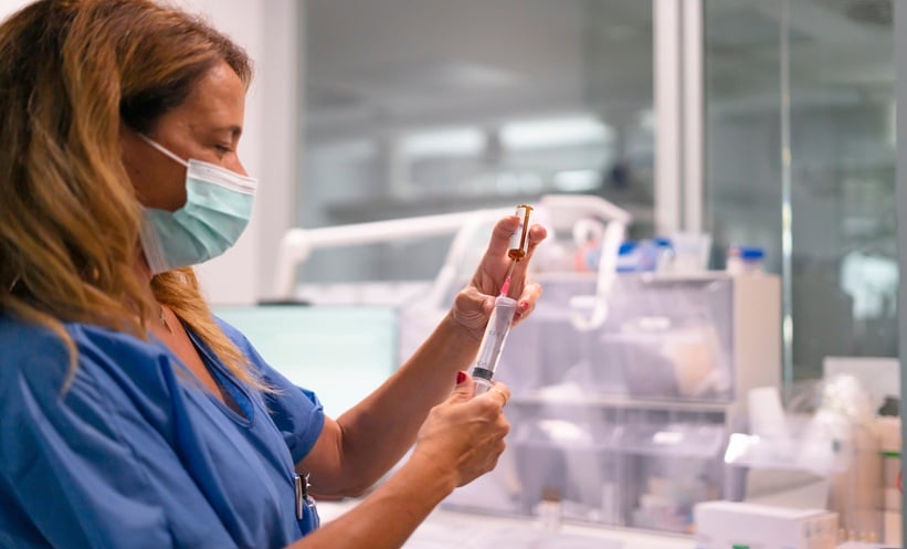 Healthcare professional preparing a vaccine injection, illustrating the Phase II/III Ebola vaccine trial targeting the Bundibugyo strain.