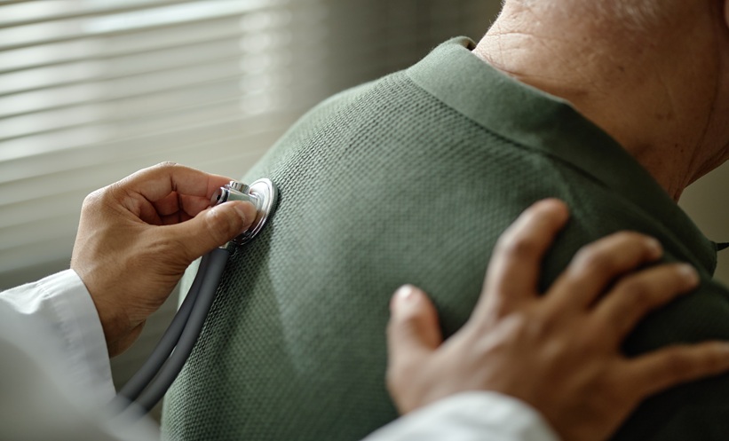 Doctor using a stethoscope to examine the lungs of a patient with idiopathic pulmonary fibrosis.