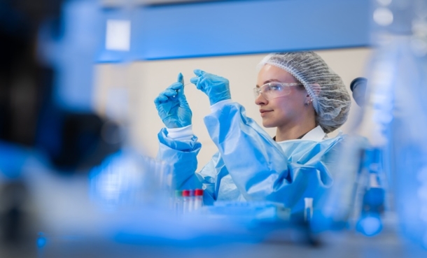 Laboratory scientist examining a sample while conducting diagnostic testing, illustrating the role of laboratory analysis in melanoma diagnosis.