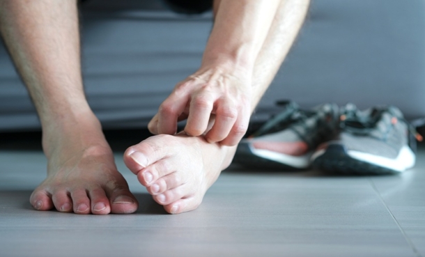 Person scratching an irritated foot, illustrating eczema and contact dermatitis symptoms.