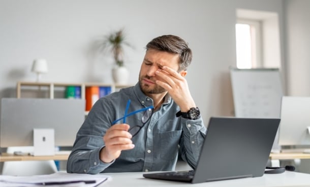 Person experiencing eye fatigue and dry eye symptoms after prolonged visual strain.