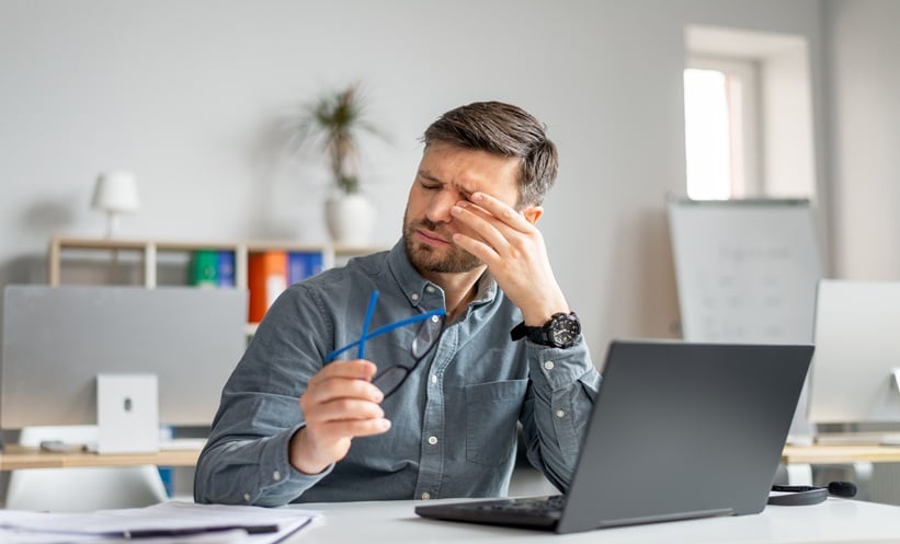 Person experiencing eye fatigue and dry eye symptoms after prolonged visual strain.