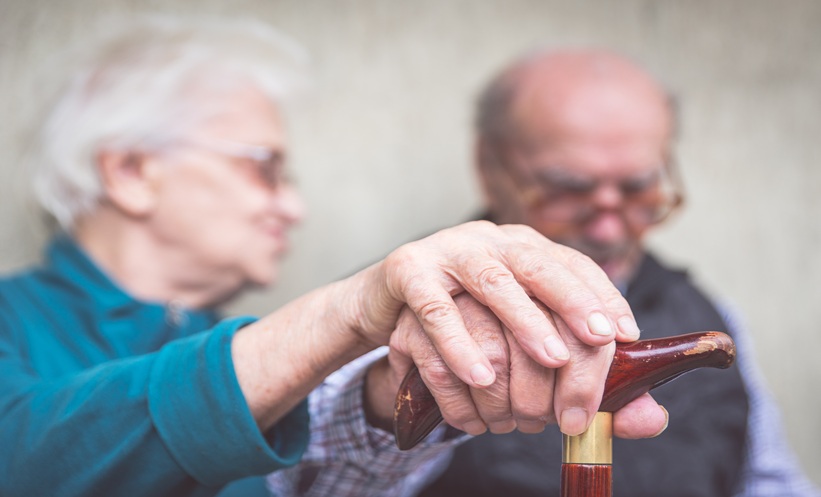 old woman comforting husband with alzheimers