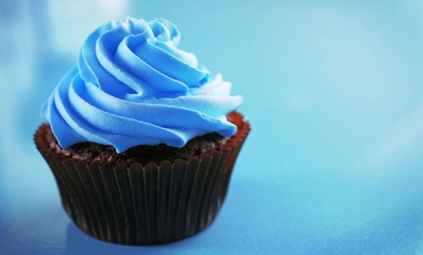 Muffin with blue icing on a blue background