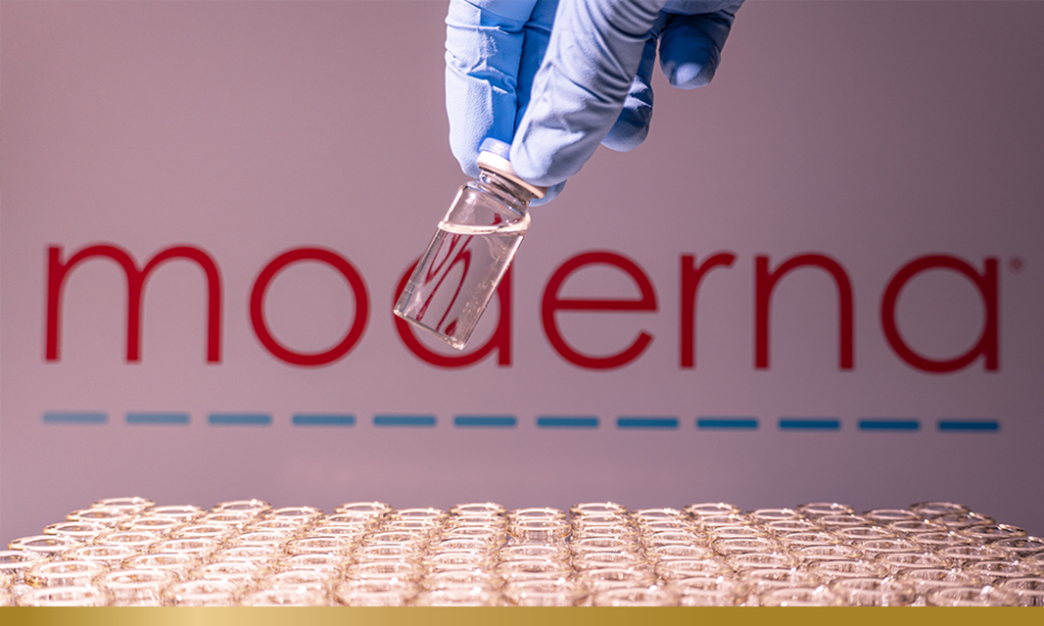Moderna name in blur. Vaccine scientist holding the glass vial with American vaccine.